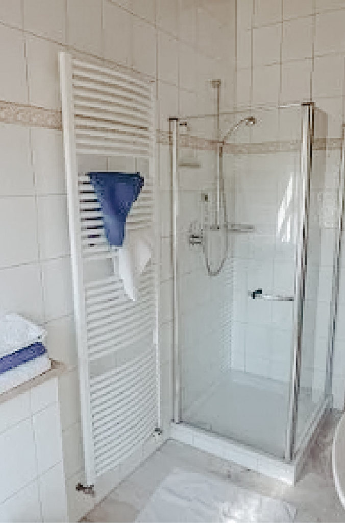 Das helle Badezimmer der Ferienwohnung mit Dusche