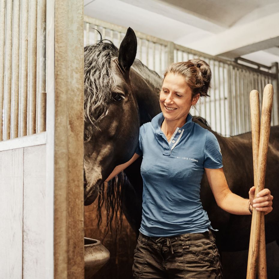 Antonia Reßle kümmert sich um ein Pferd im Stall