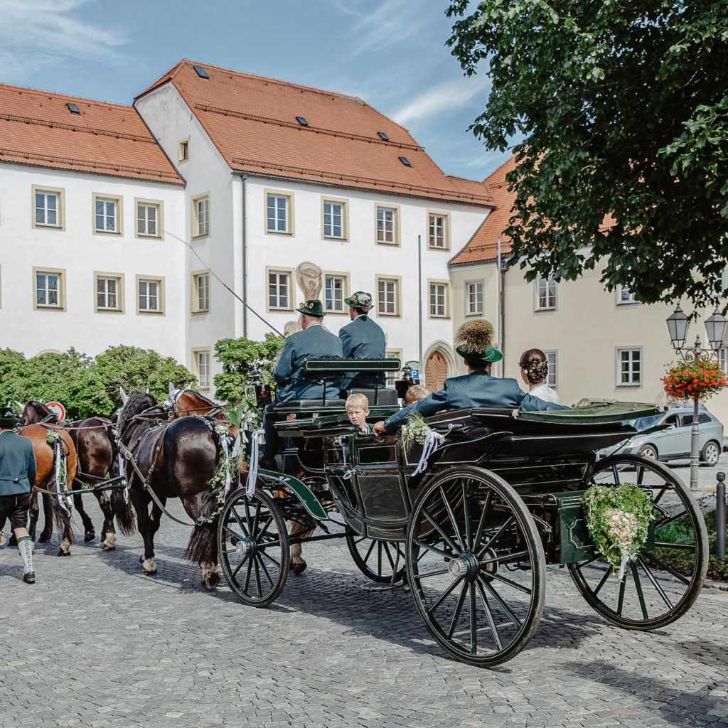 Eine Familie fährt mit der Pferdekutsche durch die Altstadt